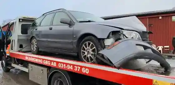 Skrotbil vid upphämtning med prisgraf för stål och aluminium som visar hur råvarupriser och lagerkapacitet påverkar ersättningen.